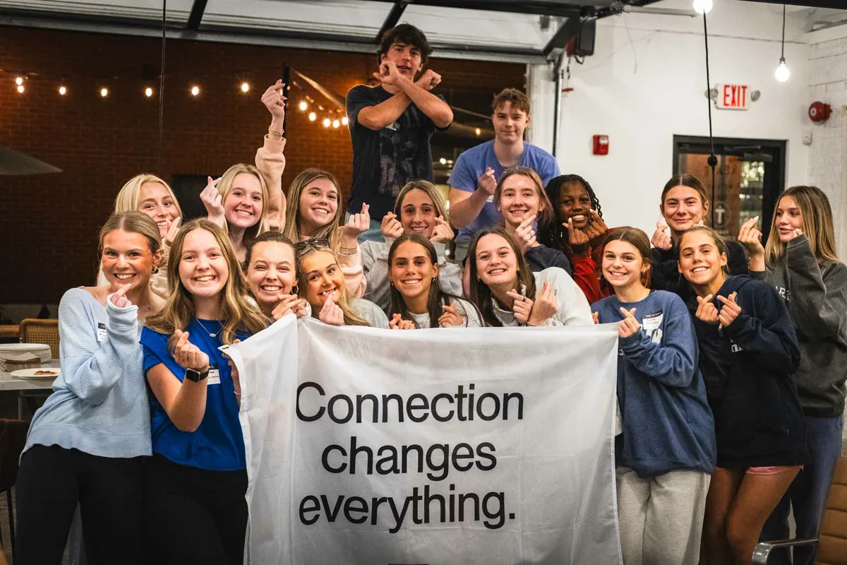 A big group of students holding a “Connection changes everything” banner