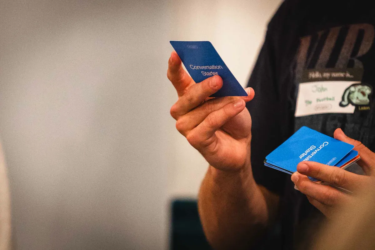 A student holding blue Whisper conversation cards